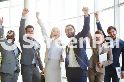 Group Of Ecstatic Business Partners Looking At Camera With Raised Arms